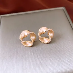 14K gold plated spiral knot stud earrings with frosted finish and pavé zircon accents