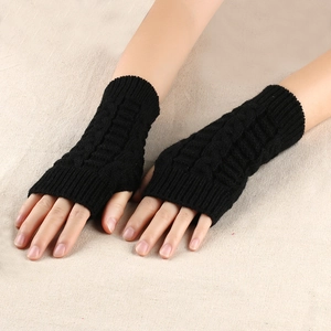 Detailed close-up of black cable-knit fingerless gloves for winter warmth and flexibility