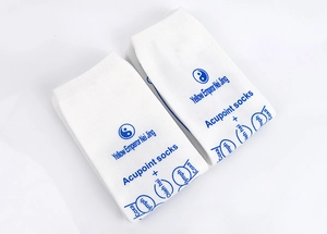 Close-up of white acupoint socks featuring printed English meridian charts and Tai Chi logo