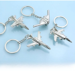 Detailed close-up of four metal airplane keychains with polished silver finish models