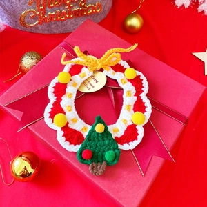 Detailed view of handmade crochet Christmas wreath with miniature tree on red gift box