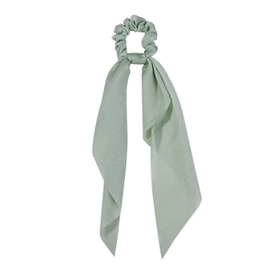 Detail of light green satin scrunchie featuring long ribbon streamers in silk texture