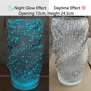 Detailed size comparison of luminous wavy glass vase in dark blue glow and daylight