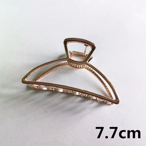Detail view of a 7.7cm rose gold alloy hair claw clip with hollowed semicircular design