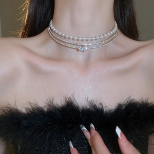 Detail of multi-layer silver choker with white pearls and sparkling rhinestone pendant