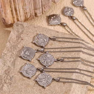 Macro detail of silver stainless steel necklaces with tarot coin pendants and zircons