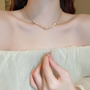 Detail of irregular shell and crystal beaded necklace on a model for an elegant fashion look