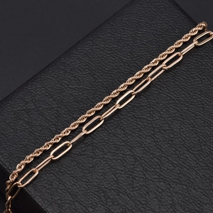 Bracelet double couche en or rose avec chaîne torsadée et trombone sur boîte en cuir