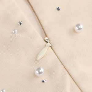 Dettaglio macro della zip invisibile su abito da sera in tulle con perle e cristalli