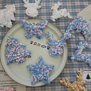 Close-up of glitter sequins embroidery patches in star and reindeer shapes