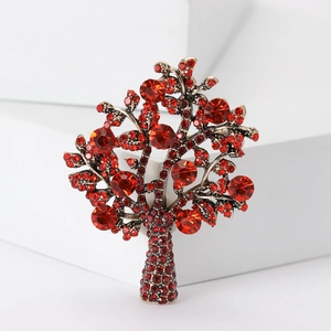 Close-up of elegant tree of life brooch featuring sparkling red rhinestones in alloy setting