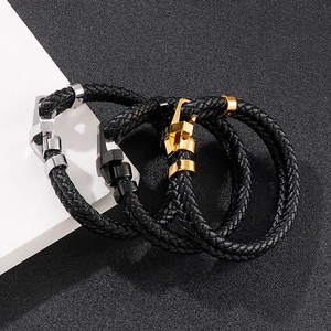 Détail de bracelets en cuir tressé avec fermoirs en acier inoxydable or, noir et argent