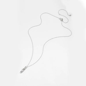 Detailed view of silver paperclip pendant with sparkling zircons on a fine chain