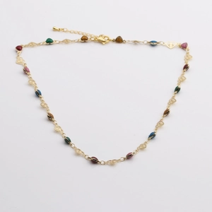 Détail d'un collier doré avec breloques en cœur et perles en émail coloré sur fond blanc