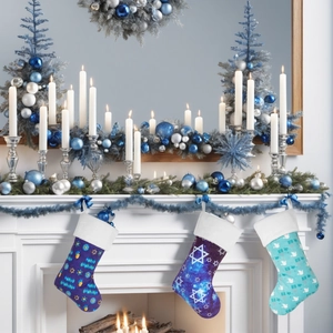 Detail of Hanukkah stockings with Star of David patterns hanging on a white fireplace