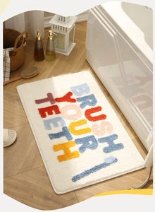 Detailed plush texture of bathroom rug with colorful Brush Your Teeth typography and graphics
