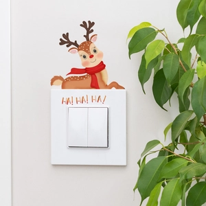 Detail of glow in the dark reindeer switch sticker with red scarf and HA HA HA text