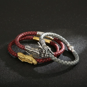 Detailed macro shot of braided leather bracelets with red and grey dragon head clasps