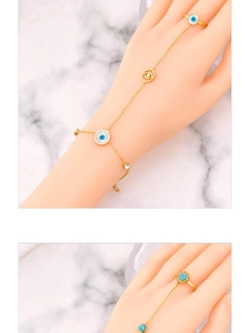 Detail of evil eye ring bracelet with mother of pearl and blue stone on marble base