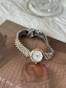 Dettaglio della fibbia in acciaio e del cinturino a maglia bicolore di questo orologio