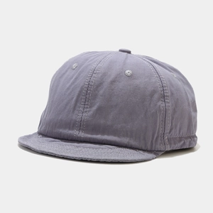 Detail of short brim cotton baseball cap showing high-quality stitching and washed fabric