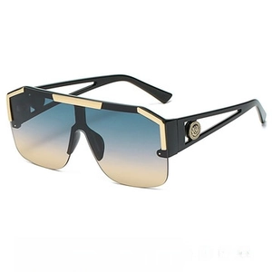 Macro shot of oversized sunglasses with gradient lenses and metal emblem on temple