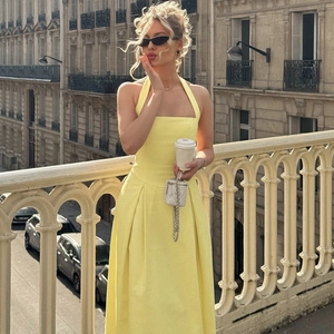 Dettaglio di un elegante abito midi giallo con scollo all'americana e vita alta vintage