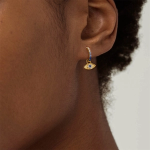 Nahaufnahme der goldenen Evil Eye Creolen mit blauen und klaren Zirkoniasteinen