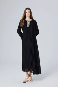 Détail du col perlé et de la texture plissée sur une robe longue noire en fourrure