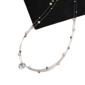 Elegant layered necklace with crystal pendant and pearls on minimalist mesh thread
