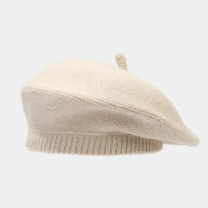 Detailed texture view of a thick warm knitted beige beret hat for women with soft wool fabric