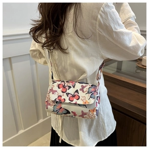 Detailed back view of a white butterfly print crossbody bag worn by a model