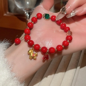 Detailed shot of red agate beaded bracelet featuring a golden horse zodiac charm