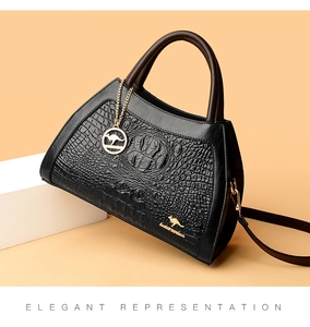 Detail of black crocodile texture handbag featuring golden kangaroo logo and hardware