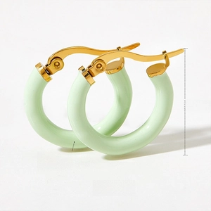 Detail shot of 20.6mm gold hoop earrings with light green enamel and leverback closure