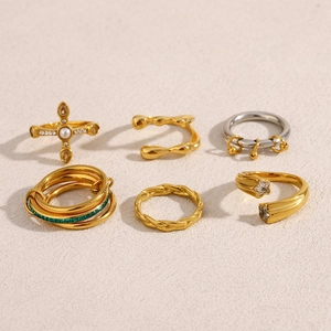 Detailed view of six-piece stacking rings with cross pearl and star charms