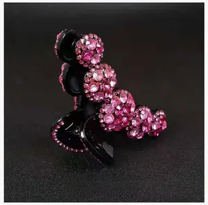 Dettaglio molletta per capelli con strass rosa a semicerchio su base nera lucida