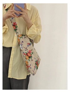 Floral canvas shoulder bag detail featuring vintage red and yellow flowers and side label