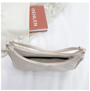 Top view of cream nylon baguette bag showing black lining and smooth metal zipper