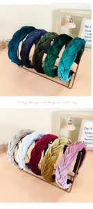 Detail of wide braided velvet headbands in multiple colors on a gold display rack