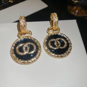 Orecchini a sospensione vintage in oro e smalto nero con design a trama intrecciata