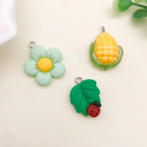 Detail von grünen Harzanhängern mit Blumen- und Blattmotiven für DIY-Schmuckherstellung