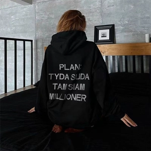 Detail of oversized black hoodie featuring white typography print on the back view
