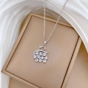 Macro view of silver swan pendant with sparkling clear crystals on silk background