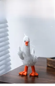 Lustige Enten-Schreibtischfigur mit frecher Geste auf Holztisch und Bürodekoration