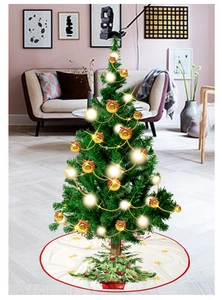 Detailed view of white Christmas tree skirt with red border and festive printed patterns