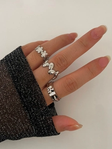 Detailansicht von drei silbernen Titanringen mit Blumenmustern und Wellenstrukturen