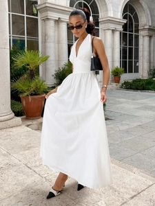 Detail of elegant white V-neck cotton maxi dress with high waist and A-line skirt flow