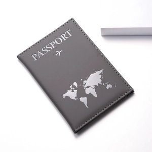 Detail of grey PU leather passport cover with world map silhouette and embossed lettering