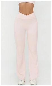 Détail du pantalon de yoga évasé rose à taille haute avec ceinture croisée et poches